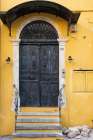 Greece, Crete, Chania, Old Town. Black double doorway in yellow wall. Art Print